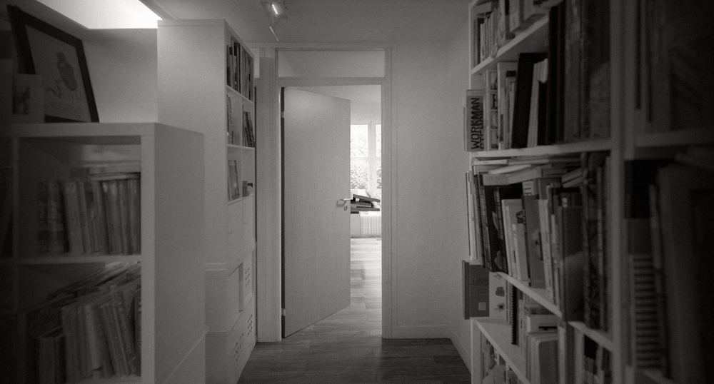 Couloir de l’atelier bordé de bibliothèques remplies de livres d’art